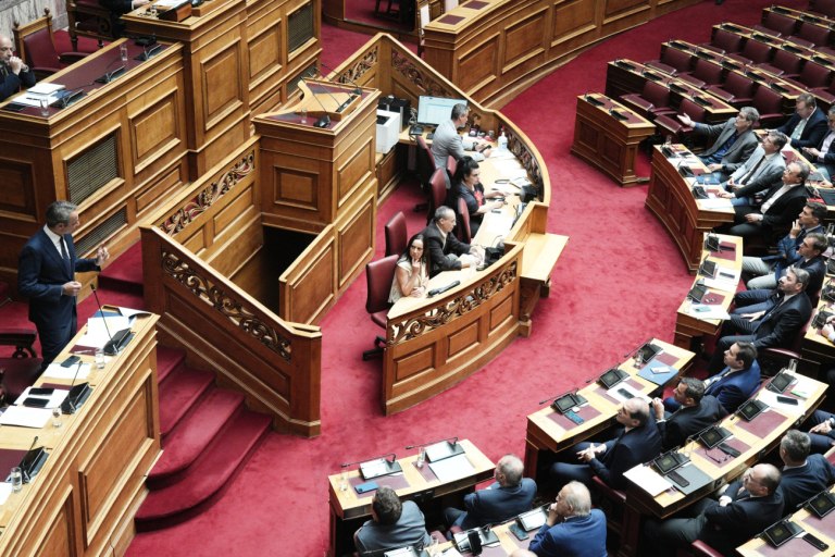 εικόνα που δείχνει τον Μητσοτάκη στα κυβερνητικά έδρανα της Βουλής να έχει πάρει τον λόγο