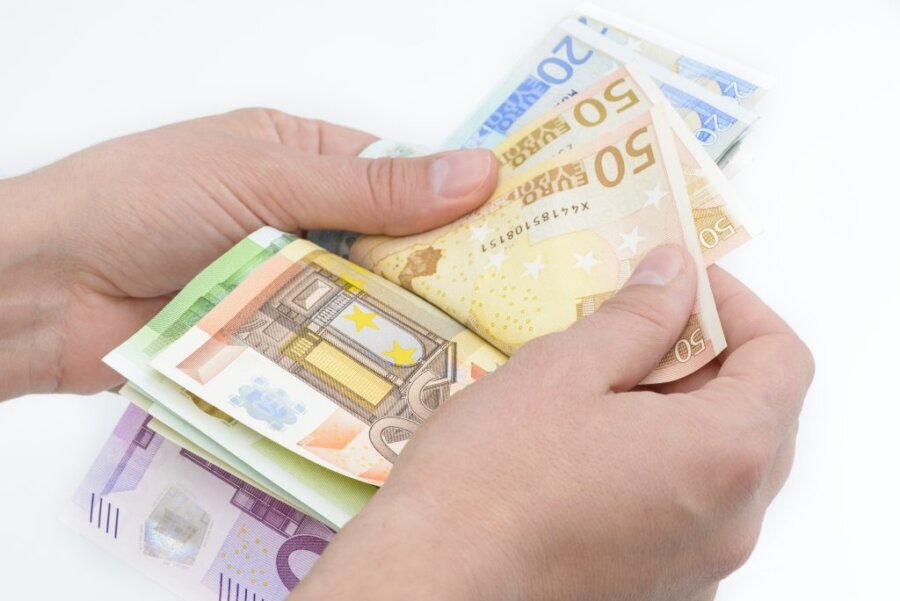 Χέρια με χαρτονομίσματα ευρώ