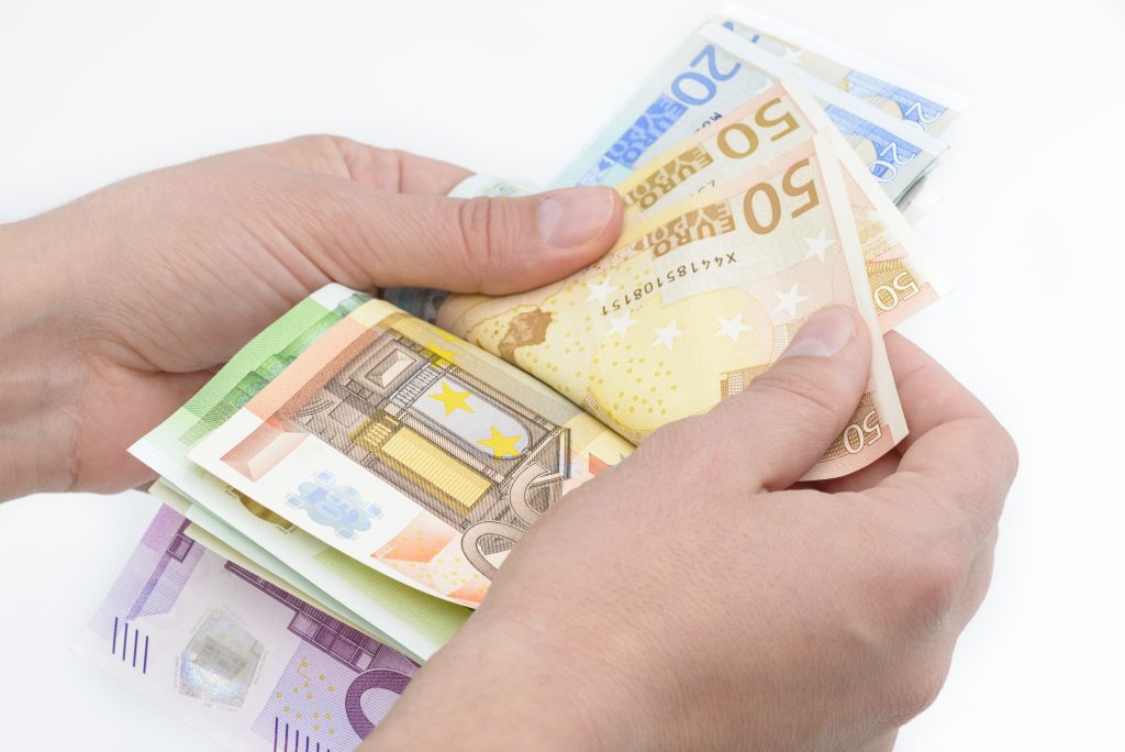 Χέρια με χαρτονομίσματα ευρώ